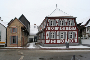  Das sanierte Ensemble in Neupotz: Links das Backsteinnebengebäude, rechts das Fachwerkhaupthaus und im Hintergrund die Scheune. Der hölzerne Tabakschuppen von der vorigen Seite befindet sich hinter der Scheune (siehe auch Grundriss unten) 