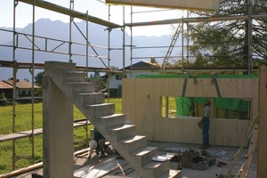  Montage der schweren Massivholzelemente auf der Baustelle. Die Treppe bauten die Handwerker aus Beton – darunter wurde später der moderne Scheitholzofen eingebaut 