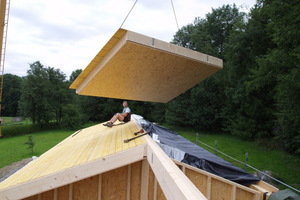  Ein Deckenelement schwebt ein. Die sägerauhe Schalung und die Dämmung sind schon eingebracht worden
Foto: Stolz Architekten  