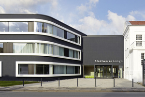  Der dunkle Erweiterungsbau (links im Bild) steht im Kontrast zum weißen Bestand (rechts im Bild). Verbindendes Elemente sind die weißen Metallrahmen der Fensterbänder am Neubau 